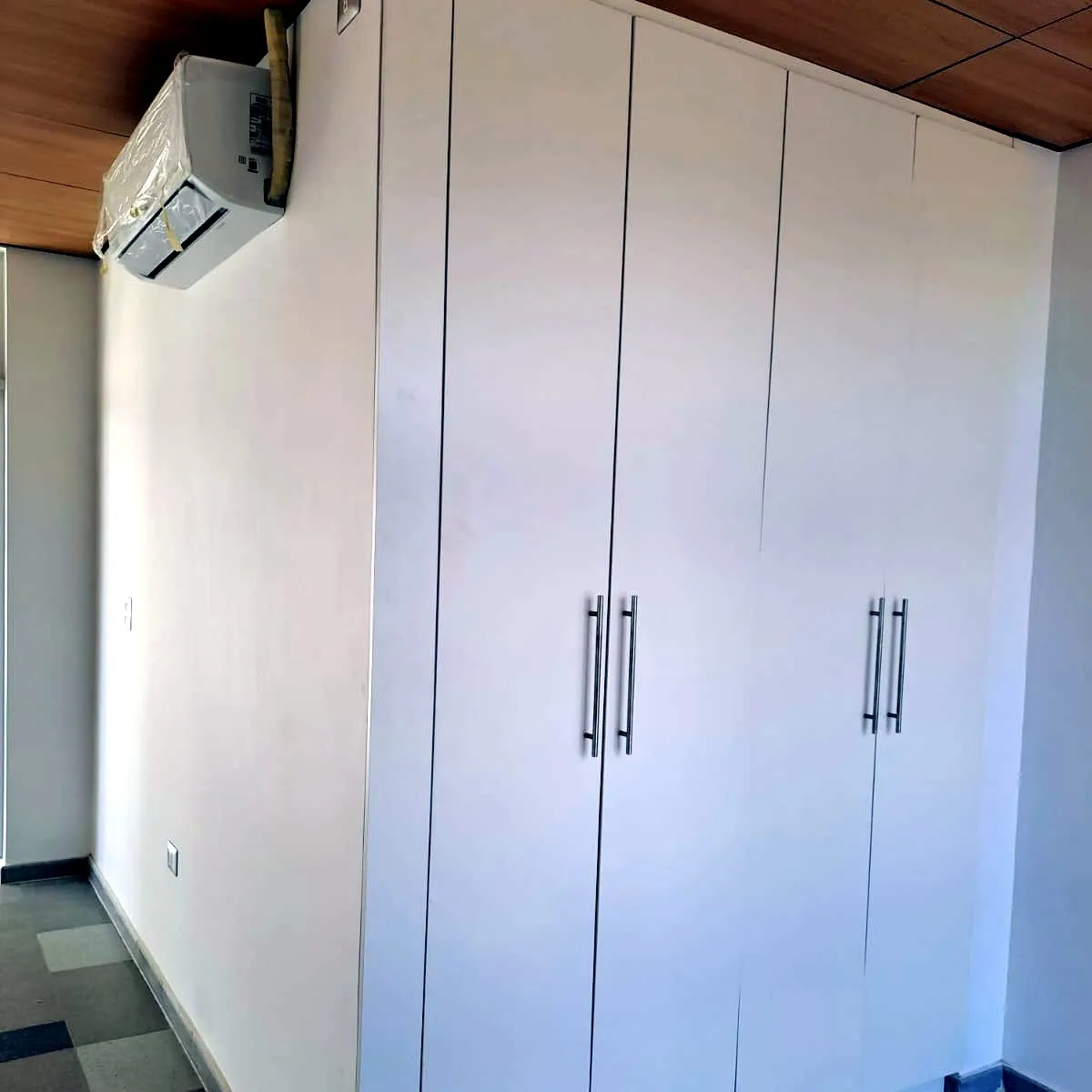Closet empotrado blanco de cuatro puertas con tiradores largos