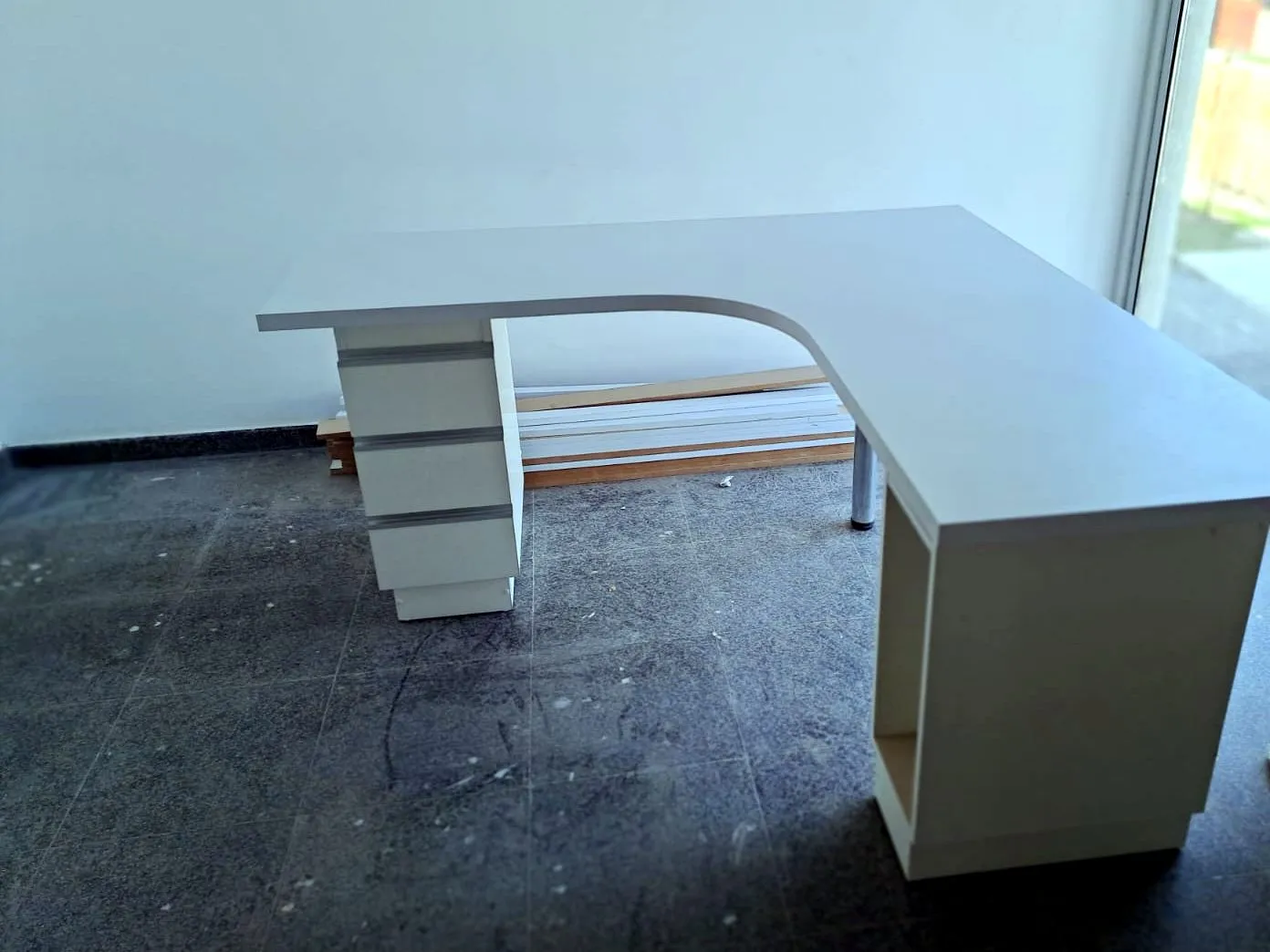 Escritorio blanco en L con esquina curva, cajonera y pata lateral